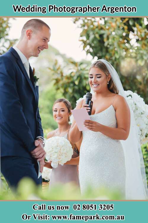 The Bride reading a note as the Groom happily listens Argenton