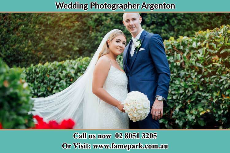 The Groom and the Bride in the garden poses for the camera Argenton