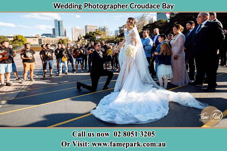 Groom Kneeling down in front of the Bride Croudace Bay NSW 2280