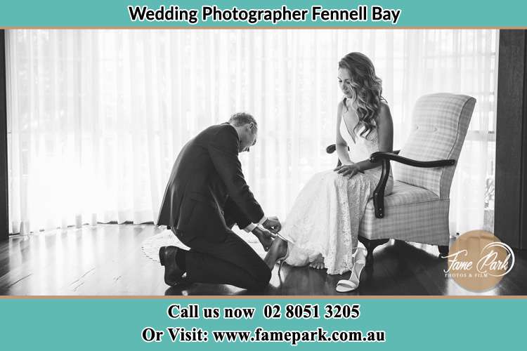 The Bride is being helped by the Groom trying to put on her shoes Fennell Bay NSW 2283