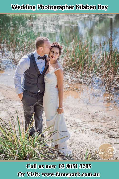 Photo of the Groom kiss the Bride near the lake Kilaben Bay NSW 2283