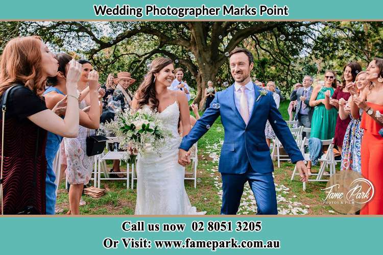 Photo of the Bride and the Groom showering bubbles by the visitors Marks Point NSW 2280